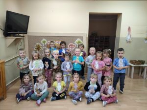 Dzieci stoją w 3 rzędach i prezentują wykonane misie