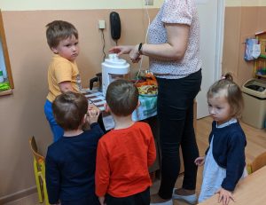 dzieci ustawione w kolejce, wyciskają sok z marchewki w sokowirówce, 