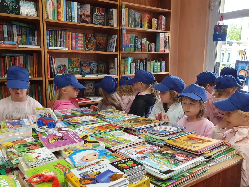 Dzieci w księgarni oglądają książki 