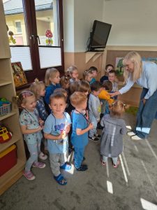 Nauczyciel częstuje maluchy skodkosciami