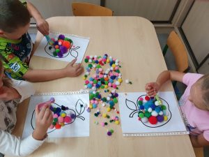 Dzieci wypełniają kontury  
Kulkami z pluszu