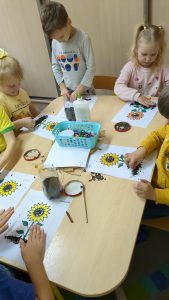 Dzieci przy stoliku robią języki z kasztanów, nasion słonecznika 