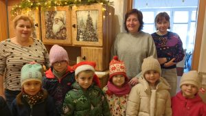 Dzieci składają życzenia w Wiślańskim Centrum Kultury. W tle wystawa w muzeum- kredensik. Na zdjęciu trzech pracowników WCK.
